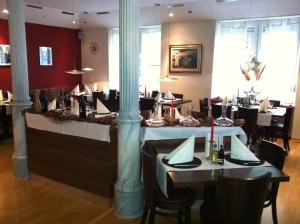 コンスタンツにあるウィーゼンテーラー ホフ ​​ホテル ガルニのテーブルと椅子が備わるレストラン
