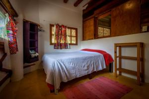 a bedroom with a white bed and a window at Casa Cereza in Holbox Island