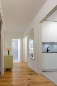 a kitchen with white cabinets and a wooden floor at Vertical Suite in Zürich +30 photos