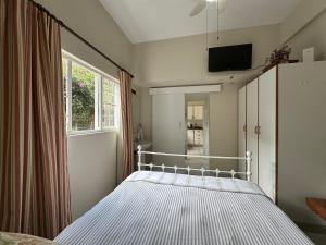 ein Schlafzimmer mit einem Bett und einem Fenster in der Unterkunft Douglas Cottage in Pennington