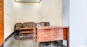 a room with a wooden desk and chairs at Hotel O Ekslusive Double'n in Solo