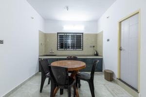 kuchnia z drewnianym stołem i krzesłami w obiekcie Tranquil Retreat w mieście Madikeri