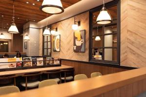 a restaurant with a bar and chairs and lights at KEIKYU EX INN Tokyo Nihombashi in Tokyo