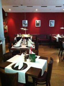 a restaurant with tables and chairs and a red wall at Wiesentäler Hof Hotel garni in Konstanz