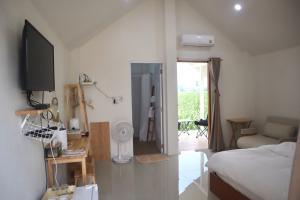 a bedroom with a bed and a tv and a living room at Tiny house homestay & cafe 5 units in Ban Mai Lao Yao