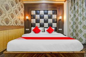 a bedroom with a large bed with red pillows at Hotel O THE HOTEL Oshin Hotel & Restaurant in Srinagar +17 photos