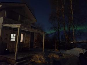 an image of a house with the northern lights at Villa Juhala in Rovaniemi