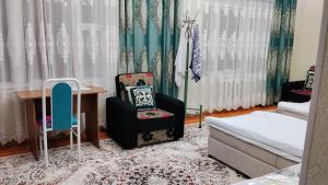 a bedroom with a bed and a desk and a chair at Asem Guest House in Kazarman
