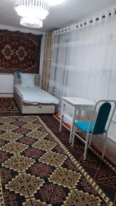 a room with a table and a couch and a table and chairs at Asem Guest House in Kazarman +4 photos