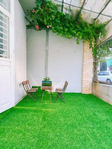 a patio with two chairs and a table on the grass at CKC Motel - Near Can Tho City Center in Can Tho