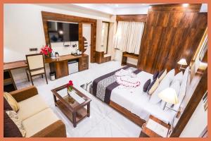 a hotel room with a bed and a living room at HOTEL - VV!NN - Hotel ! Varanasi - Providing Air conditioned & Well Decorated Rooms with Free Wi-Fi - Parking & Restaurant With Lyft Facilities - Best hotel in Varanasi in Rāmnagar