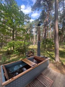 a hot tub on a deck in the woods at HATTA Las in Gąsiorowo Duże