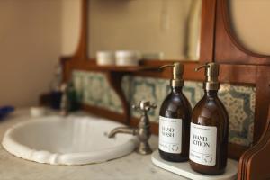 Romantic Country Cottage with log burner, garden patio, outdoor tub and country views- Brecon Beacons National Park في Llangadog: زجاجتان من النبيذ تقعان على حوض الحمام