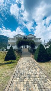 a large white house with a stone walkway in front at Seventh Heaven Villa in Hakgala