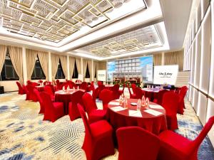 una sala de conferencias con sillas y mesas rojas en All Nite and Day Hotel Alam Sutera, en Serpong