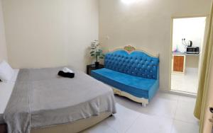 a bedroom with a bed and a blue chair at Entire studio apartment near Al ain mall in Al Ain