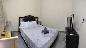 a bedroom with a bed with a blue cross on it at Entire studio apartment near Al ain mall in Al Ain
