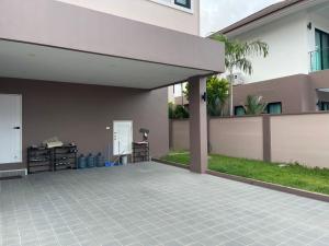 d'une terrasse avec auvent et pelouse. dans l'établissement The Lake Cozy 3BR Villa Pattaya, à Ban Huai Yai