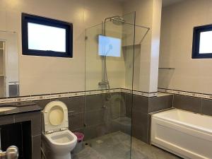 une salle de bain avec toilettes et douche en verre dans l'établissement The Lake Cozy 3BR Villa Pattaya, à Ban Huai Yai 14 autres photos