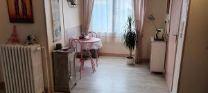 a room with a table and a chair and a window at l'ancienne épicerie in Oradour-sur-Glane