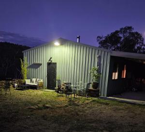 a green building with a table and chairs in the yard at The Shed in Cooma