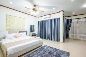 a bedroom with a bed and a ceiling fan at White Sand Pool Villa Pattaya in Jomtien Beach +32 photos