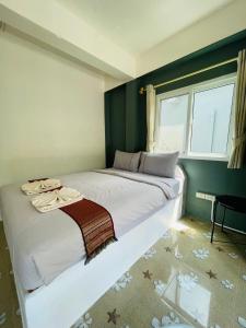 a bedroom with a large white bed with a window at Smile Resort Koh Mook in Koh Mook