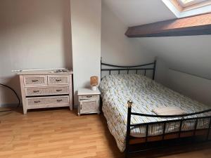 une chambre avec un lit et une commode dans l'établissement Chambre La Clé des Songes, à La Celle-sous-Gouzon