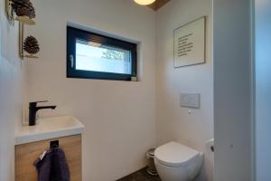 a bathroom with a sink and a toilet and a window at Wäller Haus - Modern villa with fireplace & large natural garden in Breitscheid +28 photos