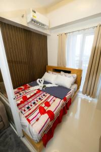 a bedroom with a bed with red flowers on it at Modern Retreat with Private Balcony in Mactan Island