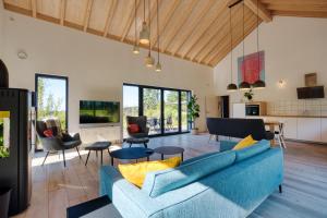 a living room with a blue couch and chairs at Wäller Haus - Modern villa with fireplace & large natural garden in Breitscheid