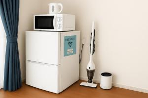 a microwave sitting on top of a refrigerator at Highness Gojo - Vacation STAY 18191 in Dazaifu