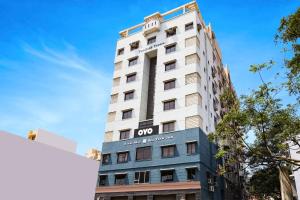 Un edificio alto y blanco con un cartel. en Hotel O Sea View Inn, en Chennai