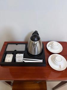 a tea pot and plates on a table at Isabelle Hotel in Puerto Princesa City
