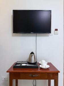 a wooden table with a television on top of it at Isabelle Hotel in Puerto Princesa City