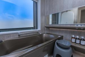 a bathroom with a tub and a toilet and a window at Vast Bleu IWAYA in Awaji +26 photos