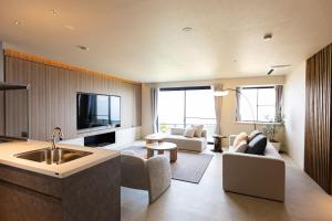 a kitchen and living room with a couch and a tv at Vast Bleu IWAYA in Awaji