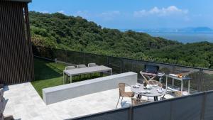 a patio with a table and chairs on a balcony at Vast Bleu IWAYA in Awaji