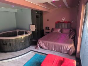 a bedroom with a large bed and a bath tub at Chambre Romantique avec Spa Privé Intérieur in Rimons