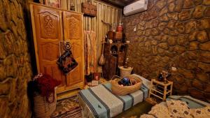a room with a stone wall and a bed with a basket at Château Berbère Madame DELLAL in Taroudant