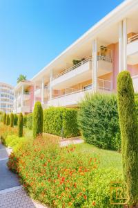 a building with bushes and flowers in front of it at Olivéa - Écrin fleuri, terrasse & plage à 5 min in Antibes +1 photo