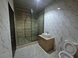 a bathroom with a shower and a toilet and a sink at Al-ihsan Metro Hotel in Kaduna
