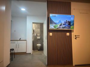 a bathroom with a flat screen tv on the wall at Bellavista Home in Trimbach