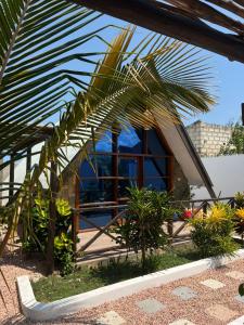 a palm tree in front of a house at Solo-A-Villa in Paje