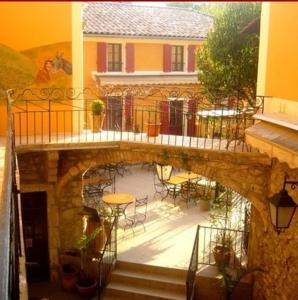 uma varanda de um edifício com uma mesa e cadeiras em Hotel l'Oronge em Saint-Jean-du-Gard