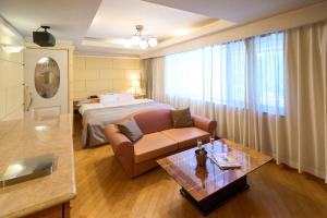 Una habitación de hotel con una cama, un sofá y una mesa. en ホテル フェスタ 葉山, en Hayama