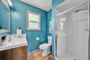 a bathroom with a toilet and a sink and a shower at @ Marbella Lane - 4BR Near Morongo Casino & Outlet Ldry+P in Banning +22 photos