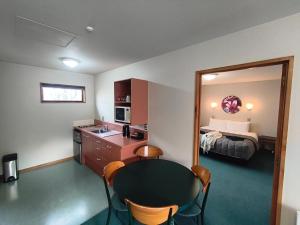 ハンマー・スプリングスにあるAspen Lodge Motelのテーブルとベッドのあるホテルの部屋