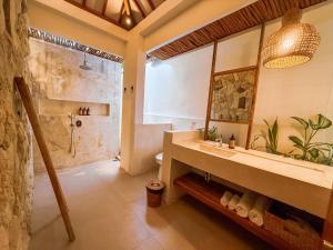 a bathroom with a shower and a sink and a toilet at Muzeum Villas II Bingin in Bingin Beach +15 photos