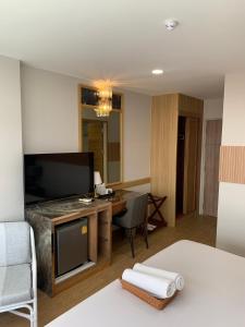 a hotel room with a desk and a television at Hotel Pattaya Beach in Pattaya Central